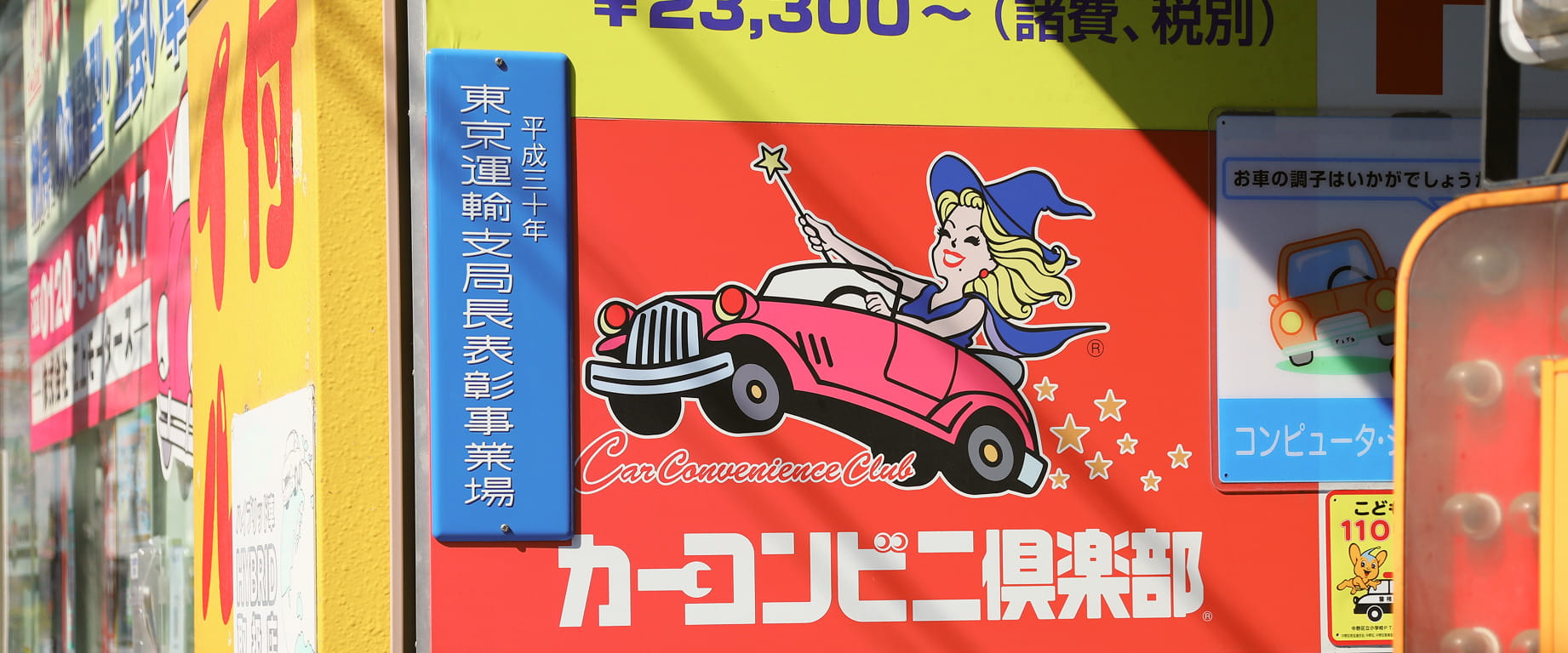 車関連の看板が並ぶ街中の風景